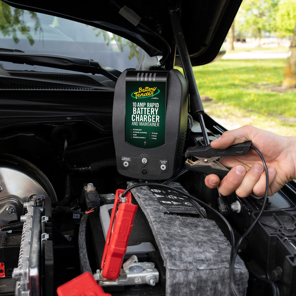 A person connects jumper cables from their Battery Tender® charger to their car battery.