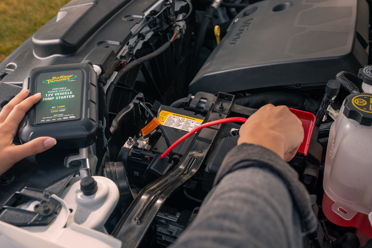 A person jump starts their vehicle with a Battery Tender jump starter.