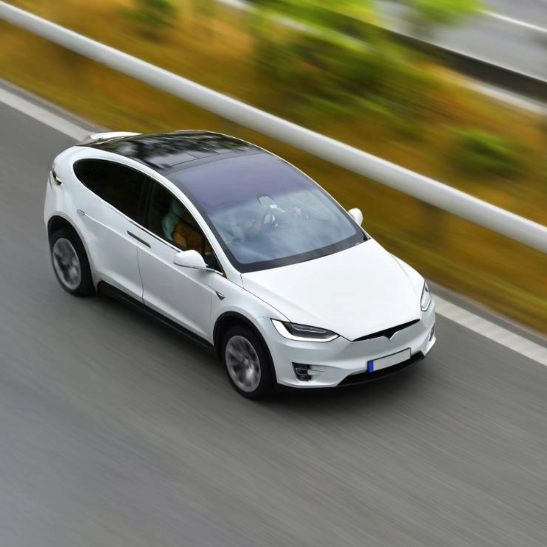 An electric vehicle drives on a highway.